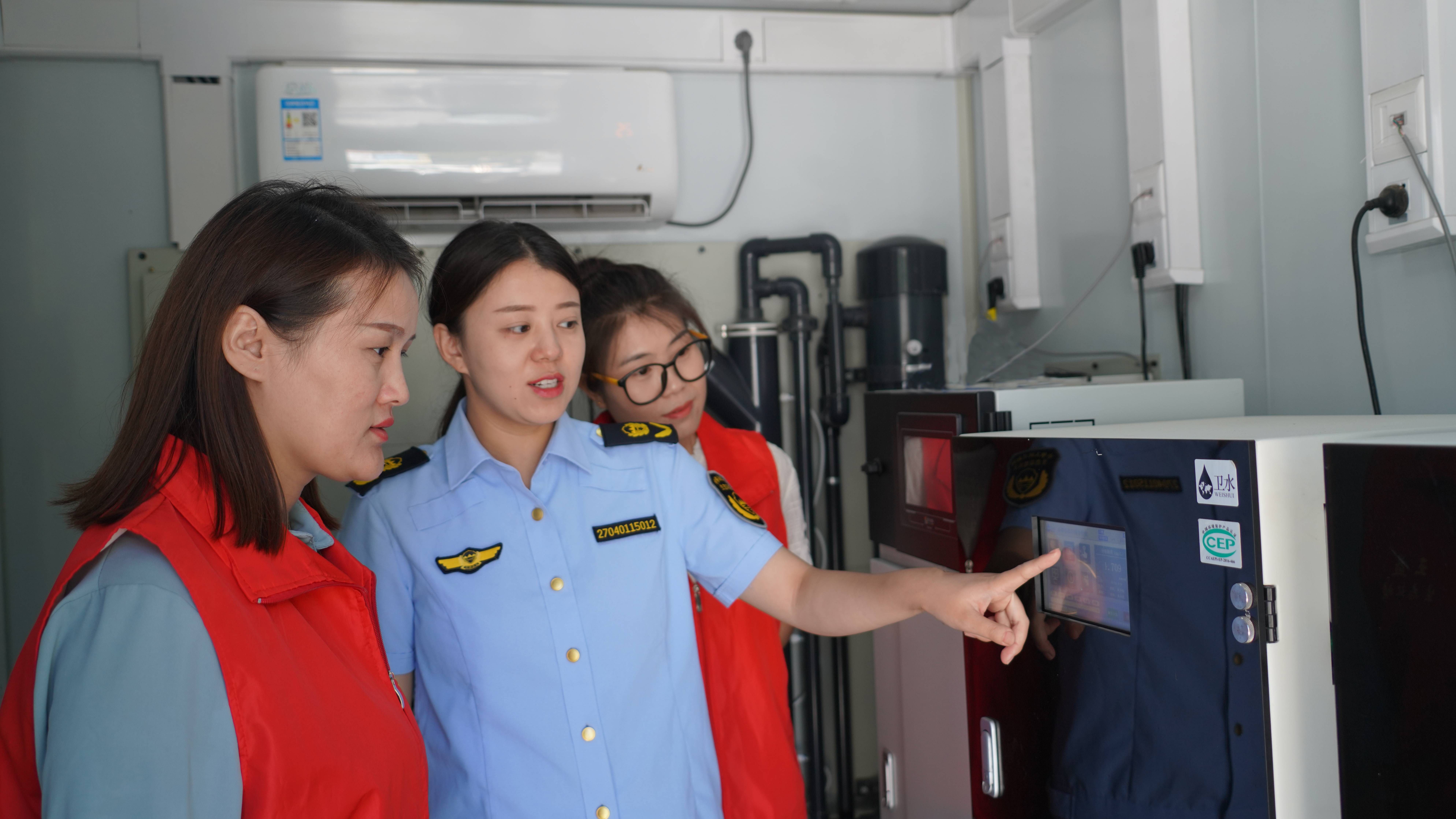 工作人员展示水质在线自动监测仪工作原理。