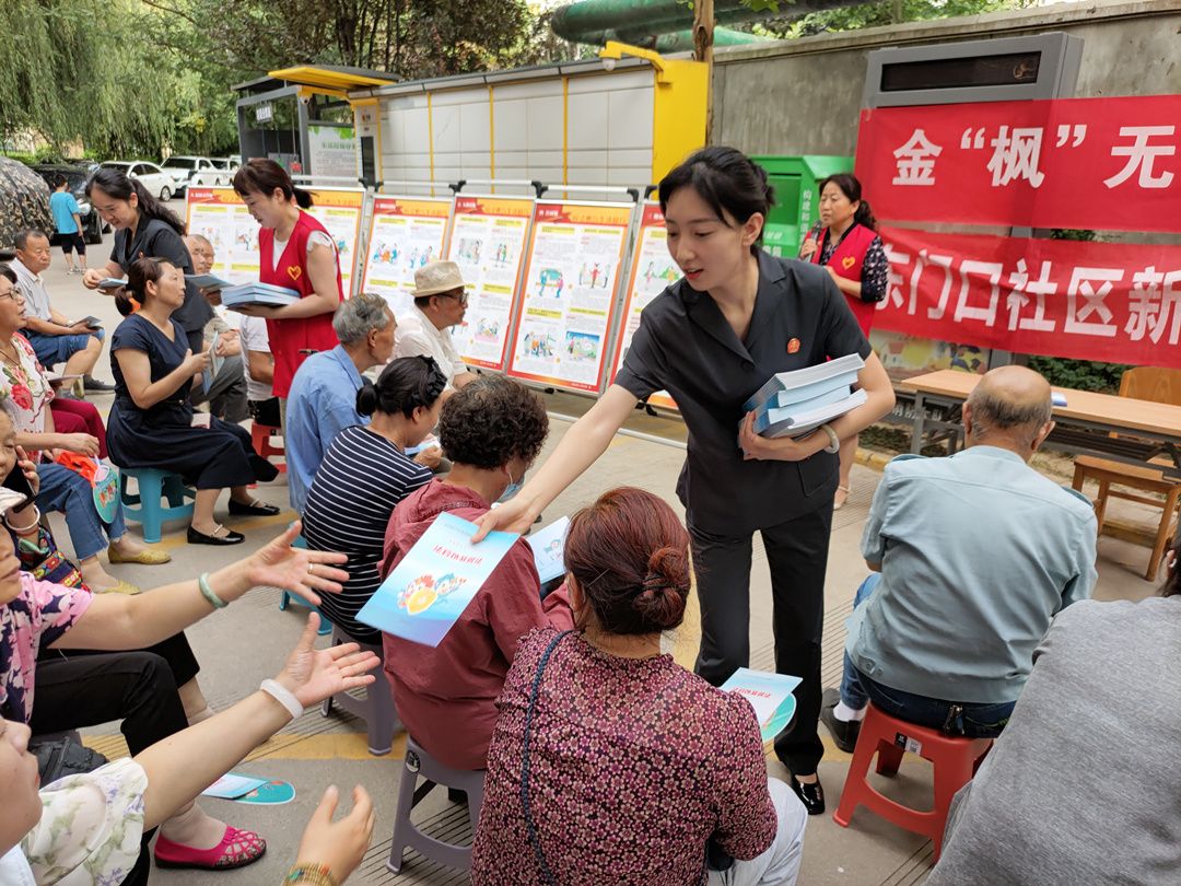 金台区人民法院干警给社区居民发放普法资料。