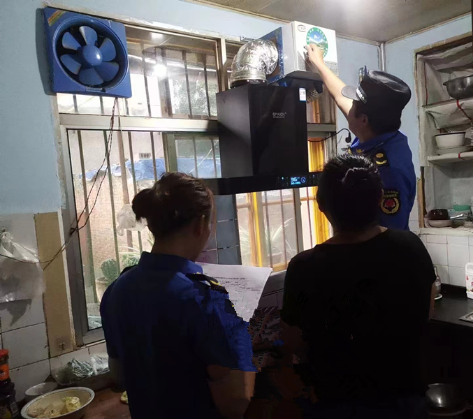 执法队员检查油烟净化设施