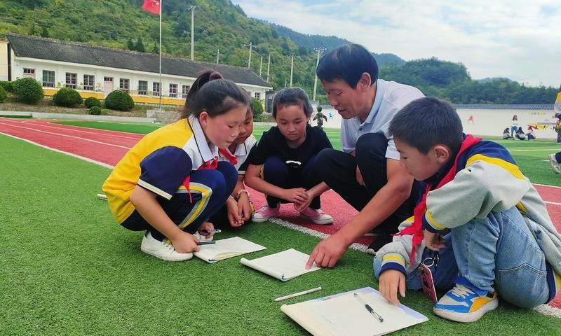 戚国敏利用课余时间给孩子们讲题。