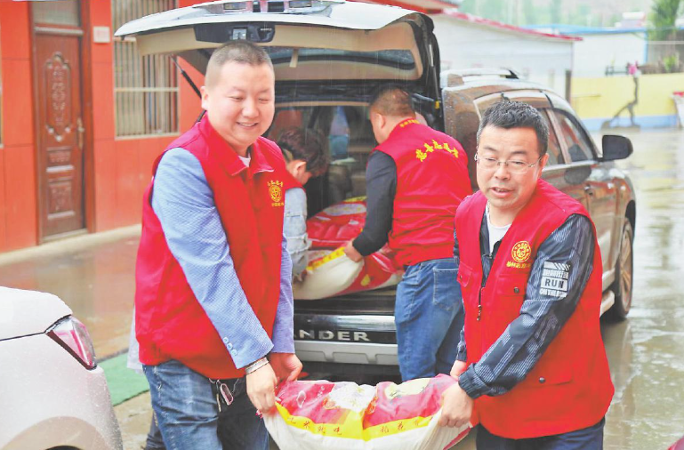 王文杰（左）与志愿者一起带着慰问品看望孤寡老人。杨晓慧 摄