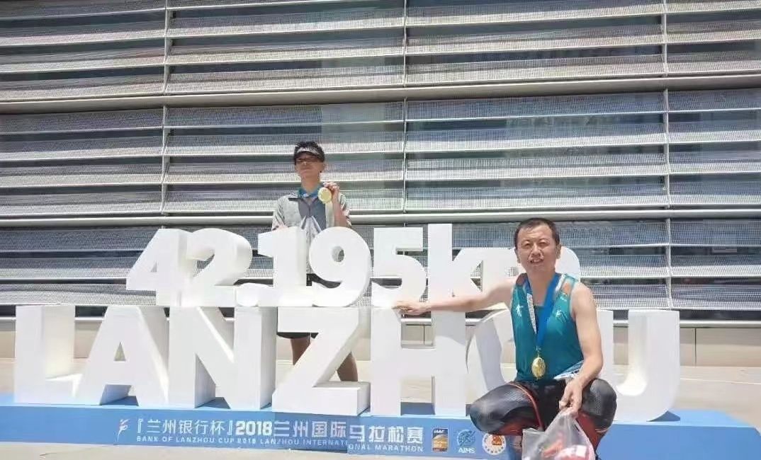 参加兰州马拉松比赛后王斌(前)在比赛标志处留念