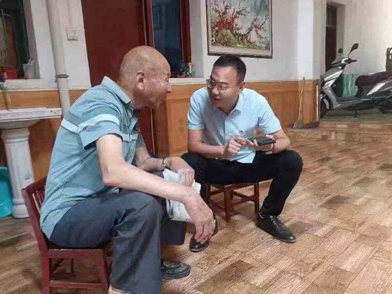 大明镇白泉村第一书记(图右)为老党员送读党报(本文图片由大明镇人民政府提供)