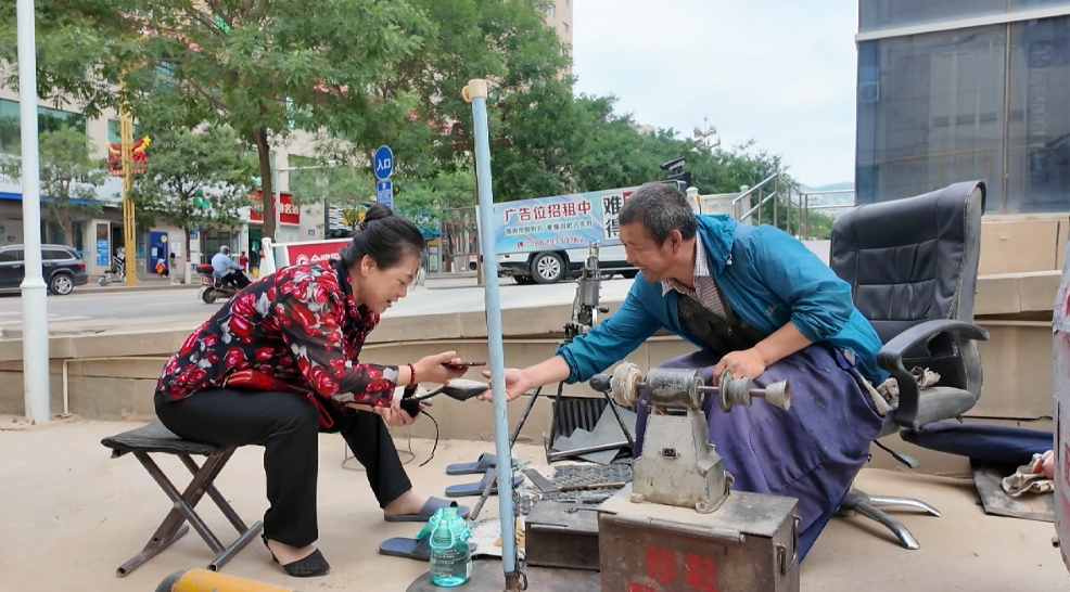 市民在吴起县长征街工商巷子修补皮鞋