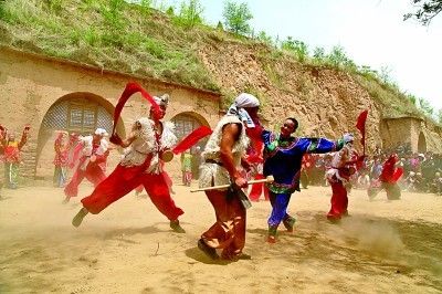 横山老腰鼓队员在窑洞前演出。吴静心 摄