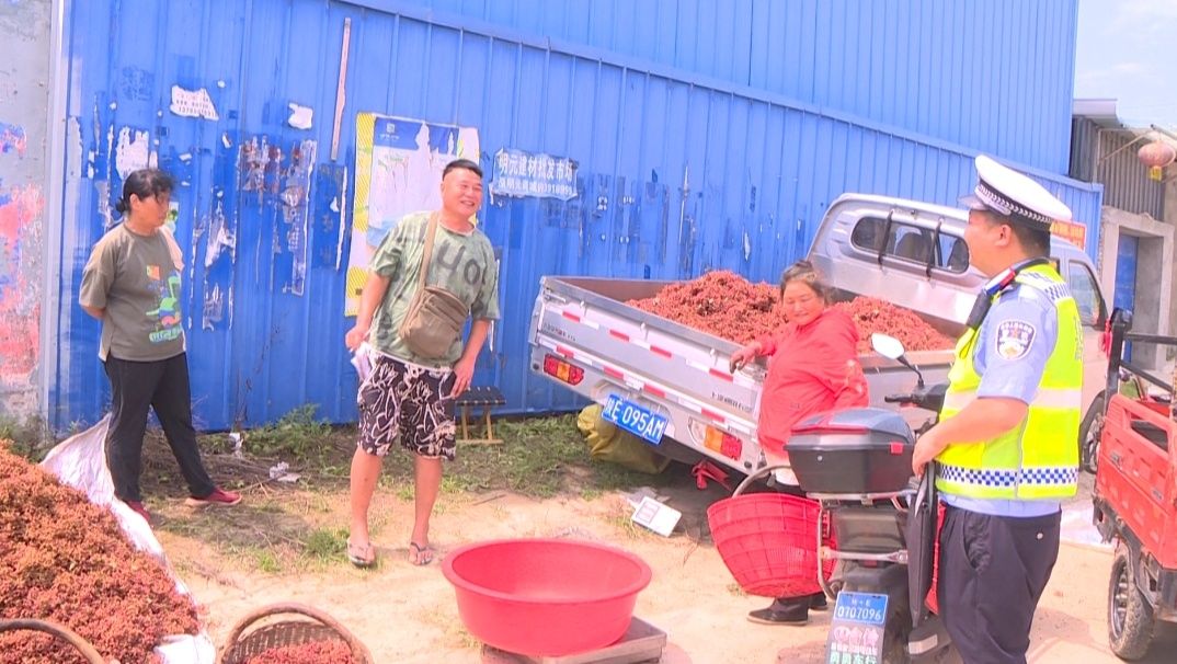 交警提醒路边收购花椒的商贩注意安全