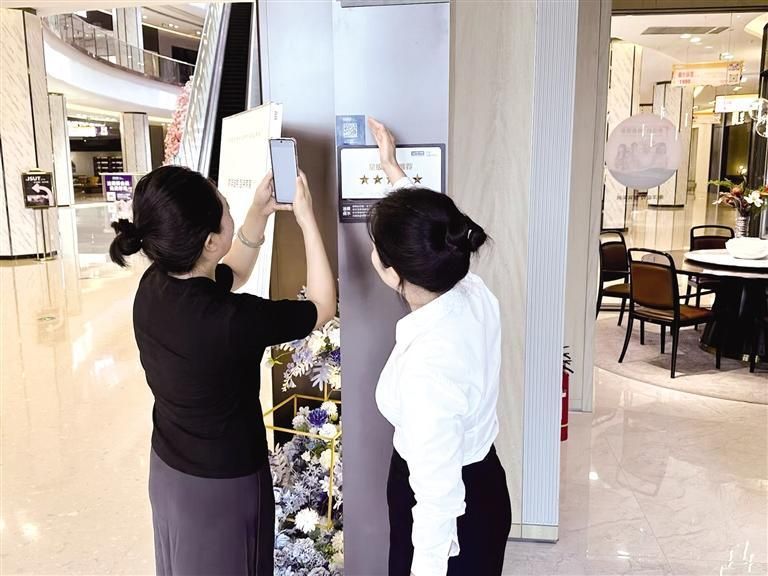 8月13日，在红星美凯龙至尊MALL家居商场内，销售经理孙婷引导顾客扫码查看品牌信息。