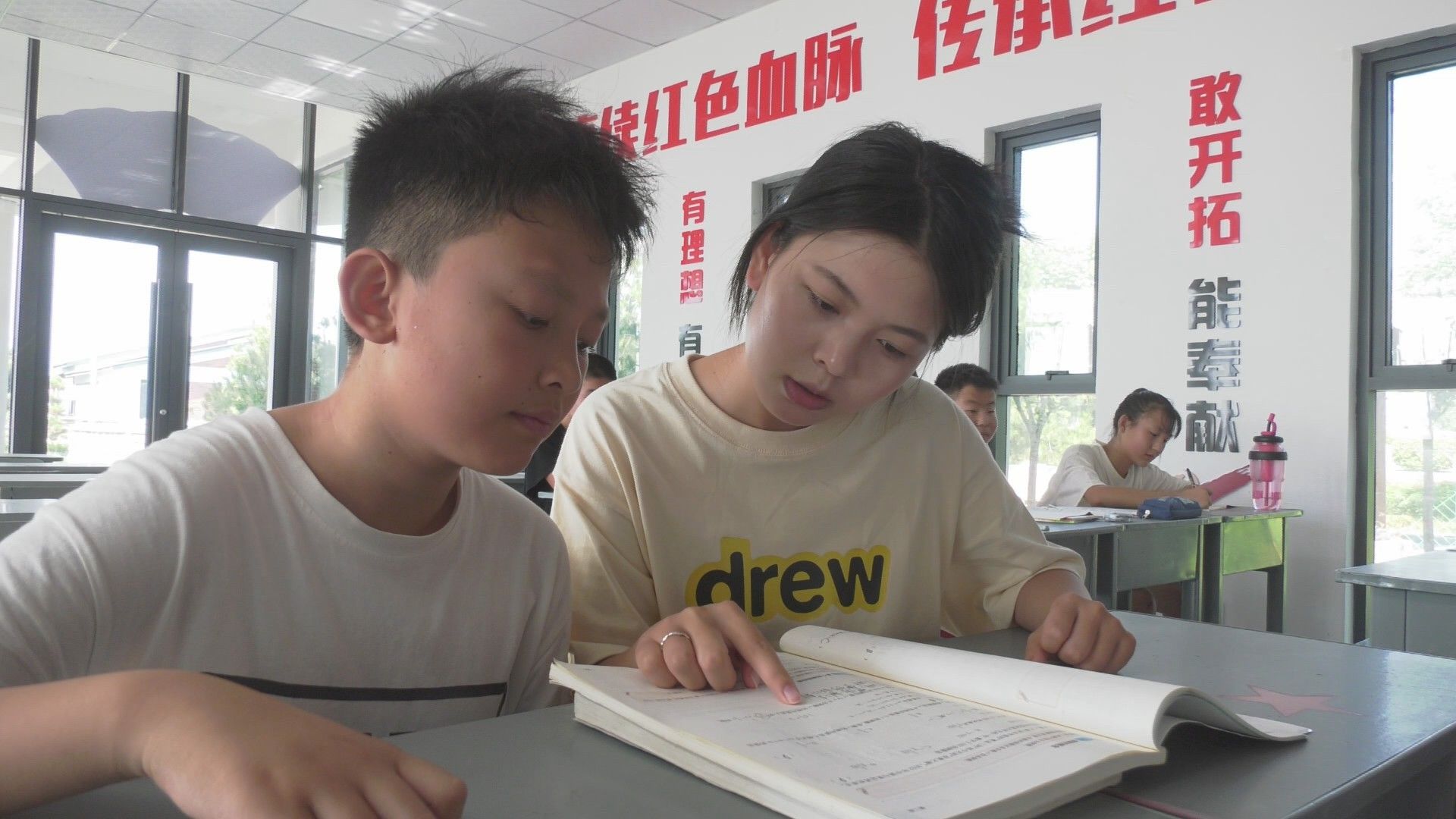 返乡大学生正在给村里放暑假的学生辅导作业(本文图片来自富平县融媒体中心)