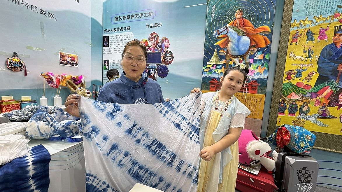 小朋友展示自己的植物扎染作品