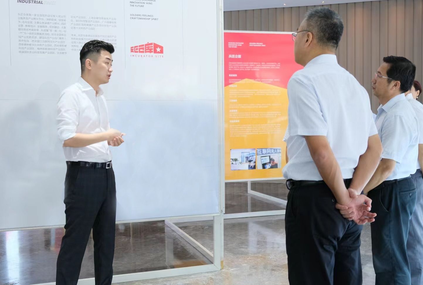 党希博（左一）向到访者介绍兵匠仓库项目情况和发展目标。