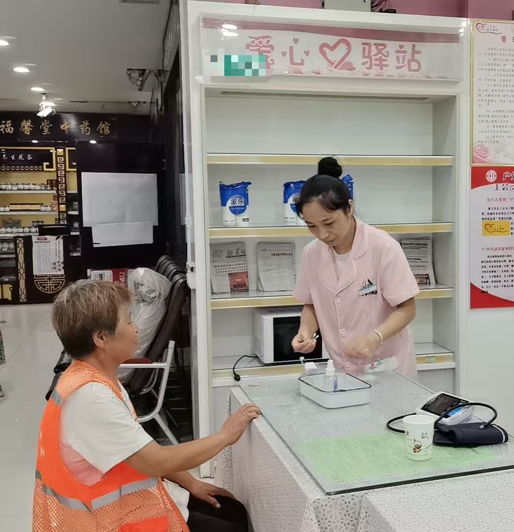 设在医药超市的爱心驿站工作人员为环卫工进行健康检查
