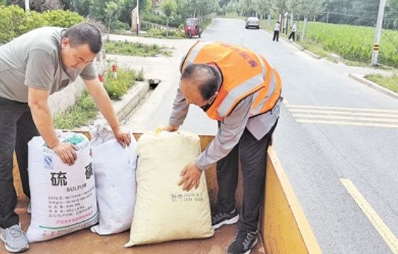 麟游县农村公路发展服务中心养护工（右）在帮助群众装粮食。杨雅芳 摄