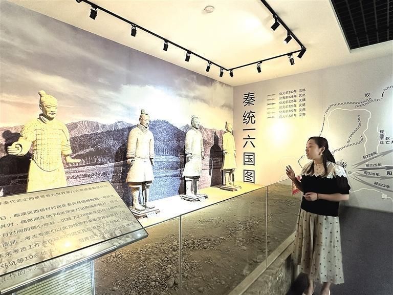 临潼区博物馆办公室副主任和理宁介绍首批出土的秦兵马俑(资料照片)。