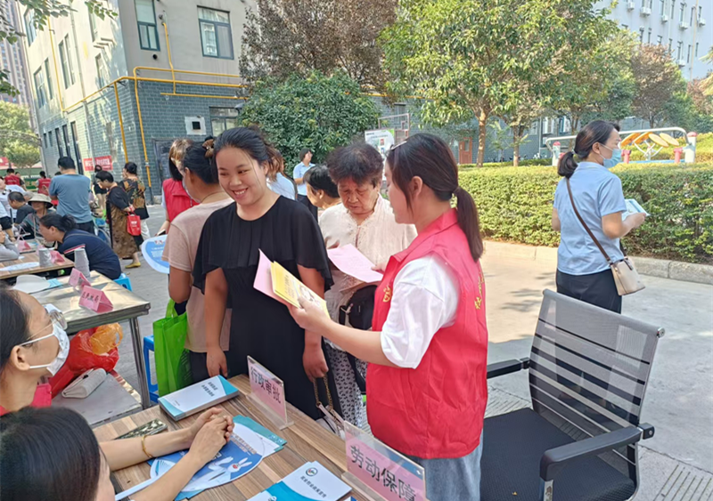 工作人员向现场群众发放政策宣传册