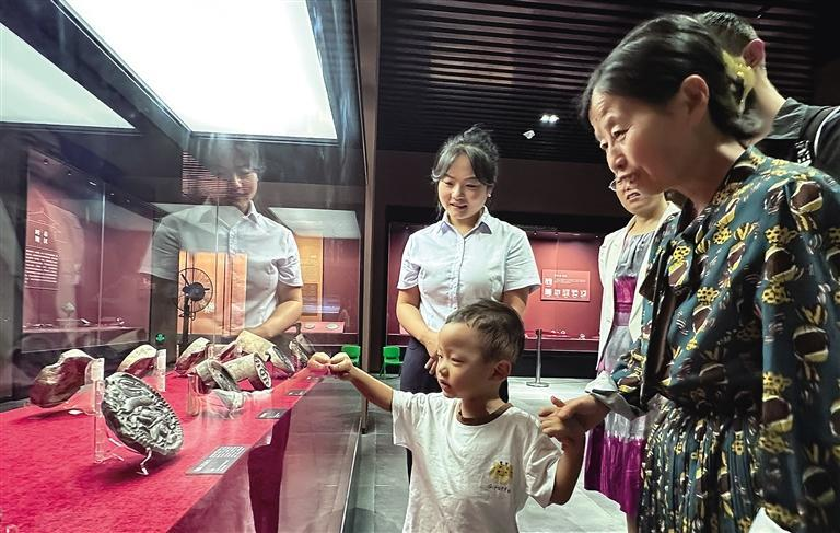 8月30日，在淳化县文博馆，年幼的郑钧鑫被汉代瓦当吸引。记者 琚鹏飞 摄