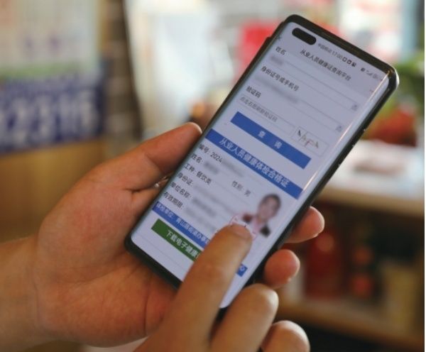 榆林市榆阳区一餐饮从业者向记者展示电子健康证。武利芳 摄